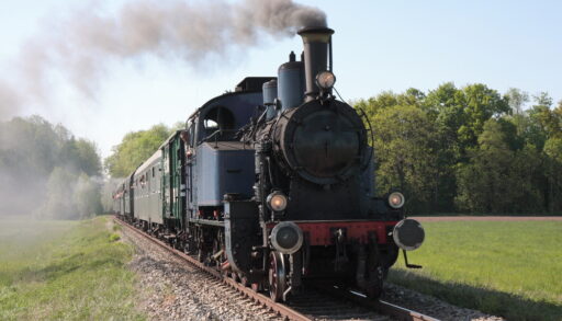 Old black steam engine train approaching.