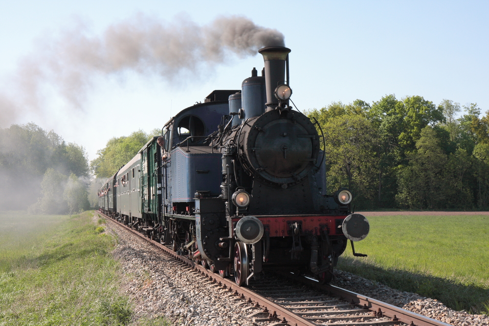 Old black steam engine train approaching.