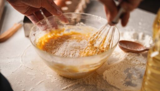 Person whisking ingredients together in a bowl.