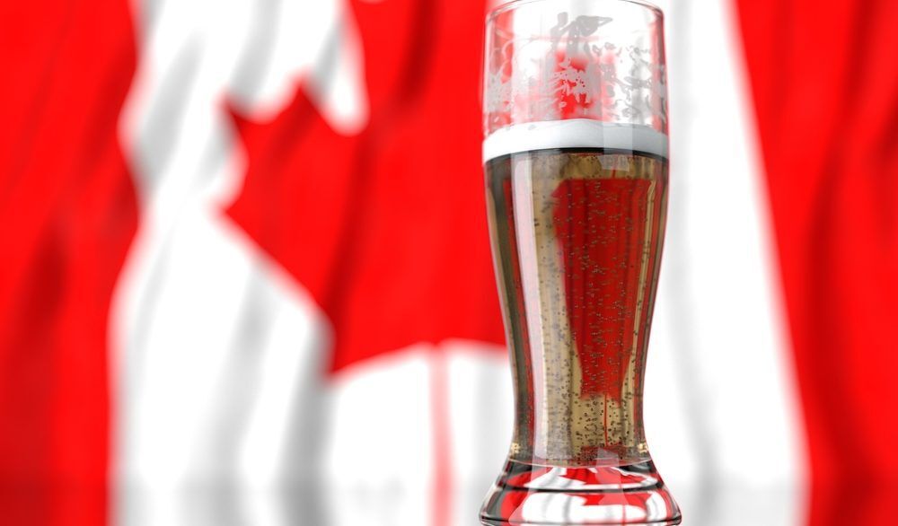 Glass of beer in front of a Canadian flag.