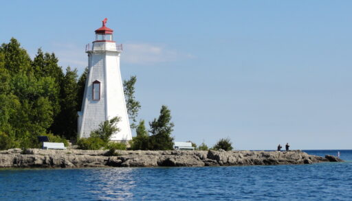 White and red lighthouse looking out over the water.