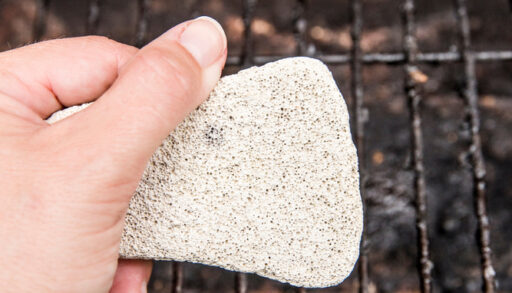 Natural pumice being used to clean a grill.