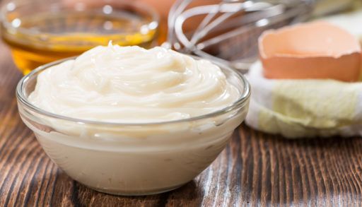 Homemade mayo on a wooden table.