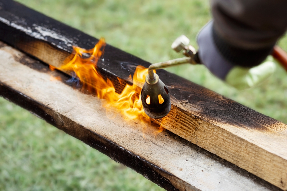 Wood being torched to achieve charred wood.