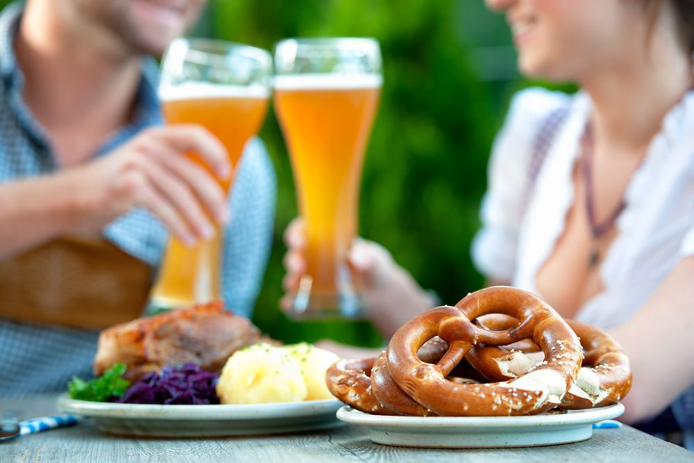 Couple having beer and a traditional Oktoberfest meal during Oktoberfest.