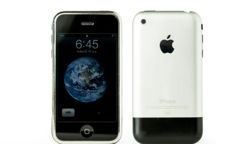 Old iPhone with a silver and black back and a world wallpaper lock screen.