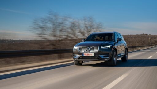 Isolated Volvo car driving down a road with a blurred landscape.