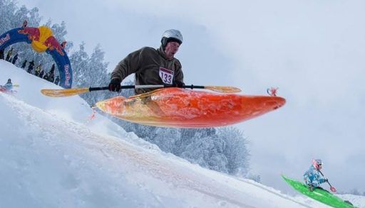 Person kayaking down a snowy hilll
