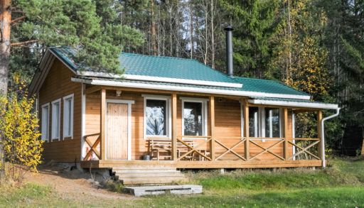 Remote wooden cabin with a green metal roof.