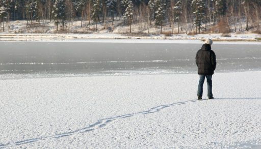 Person in a black jacket walking on thin ice.