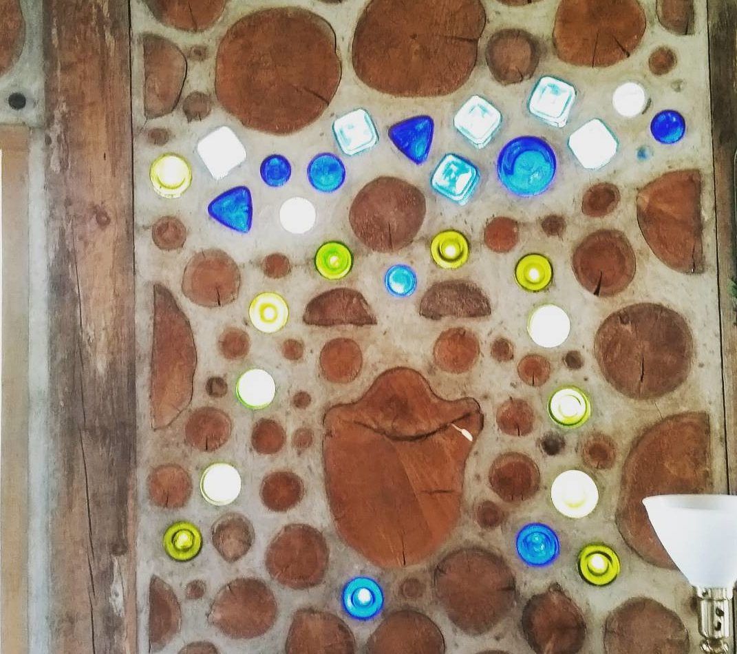Cordwood wall with colourful bottles