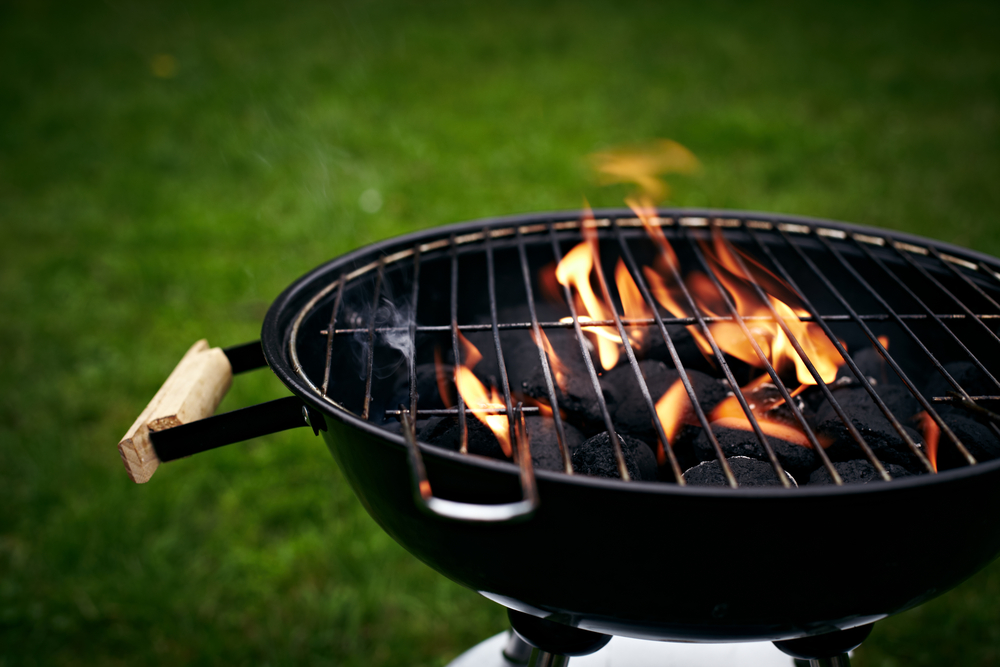 Black circular grill in a backyard.