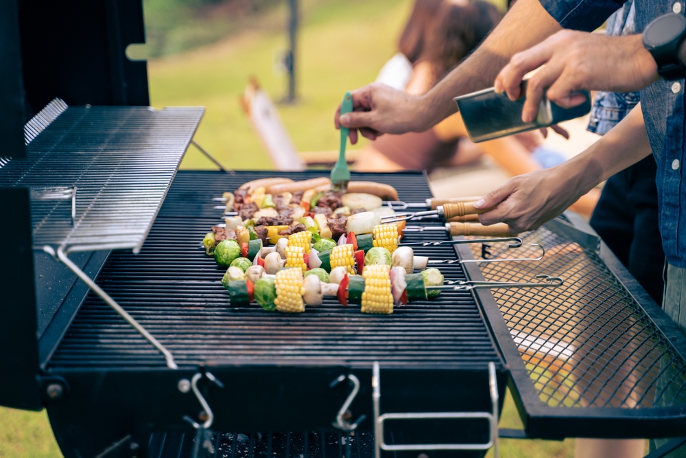 Close-up of people barbecuing food at a party.