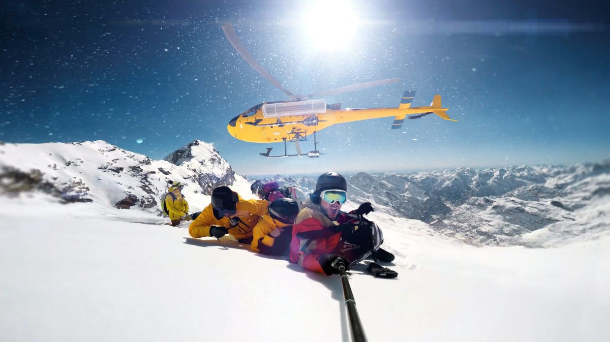 Snowboarders dropped off on a mountain for heli skiing