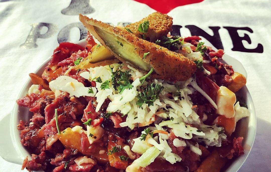 Poutine with deep fried pickles, with an "I heart poutine" shirt in the background