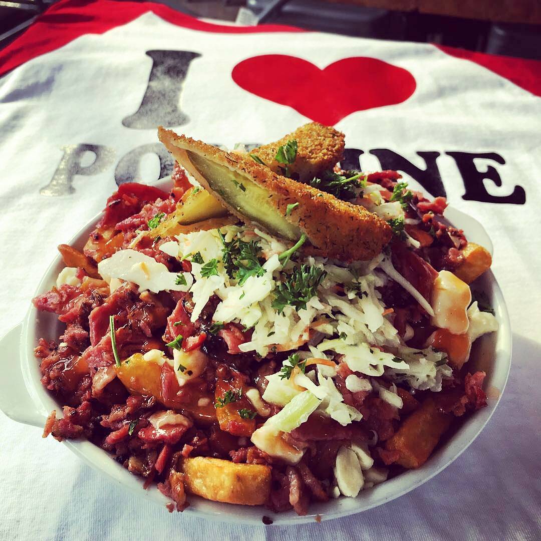 Poutine with deep fried pickles, with an "I heart poutine" shirt in the background