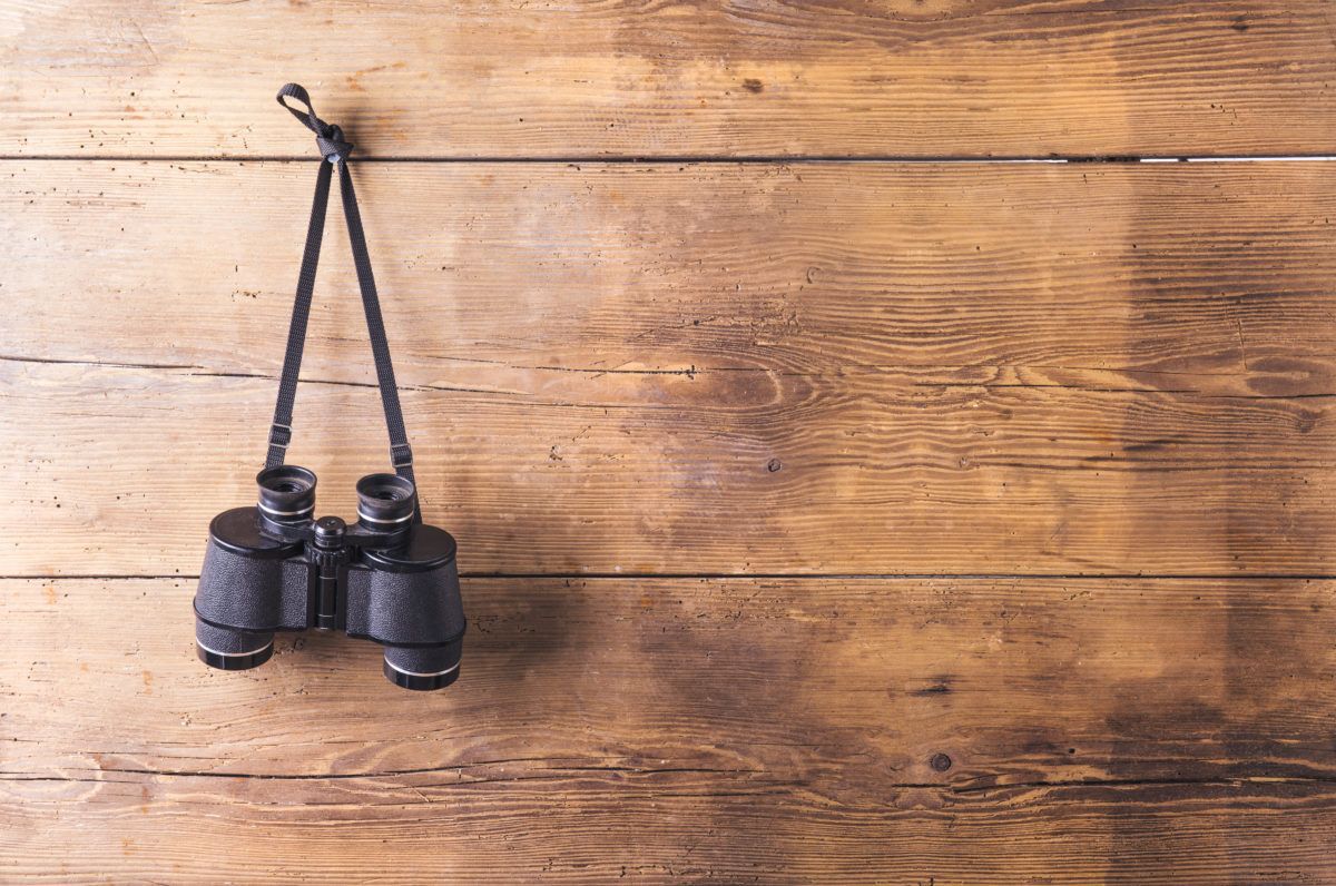 binoculars-hung-up-on-a-hook-on-wooden-wall