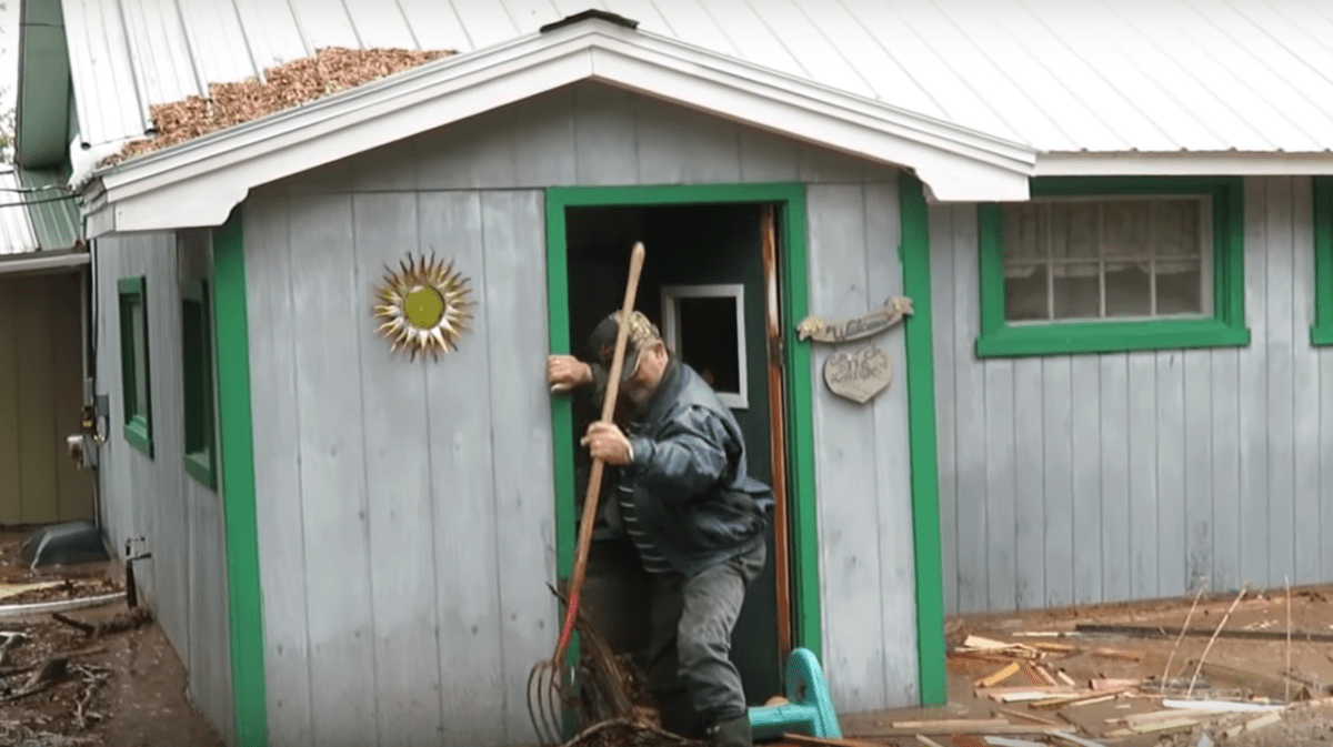 Bob McNee entering his flooded cottage