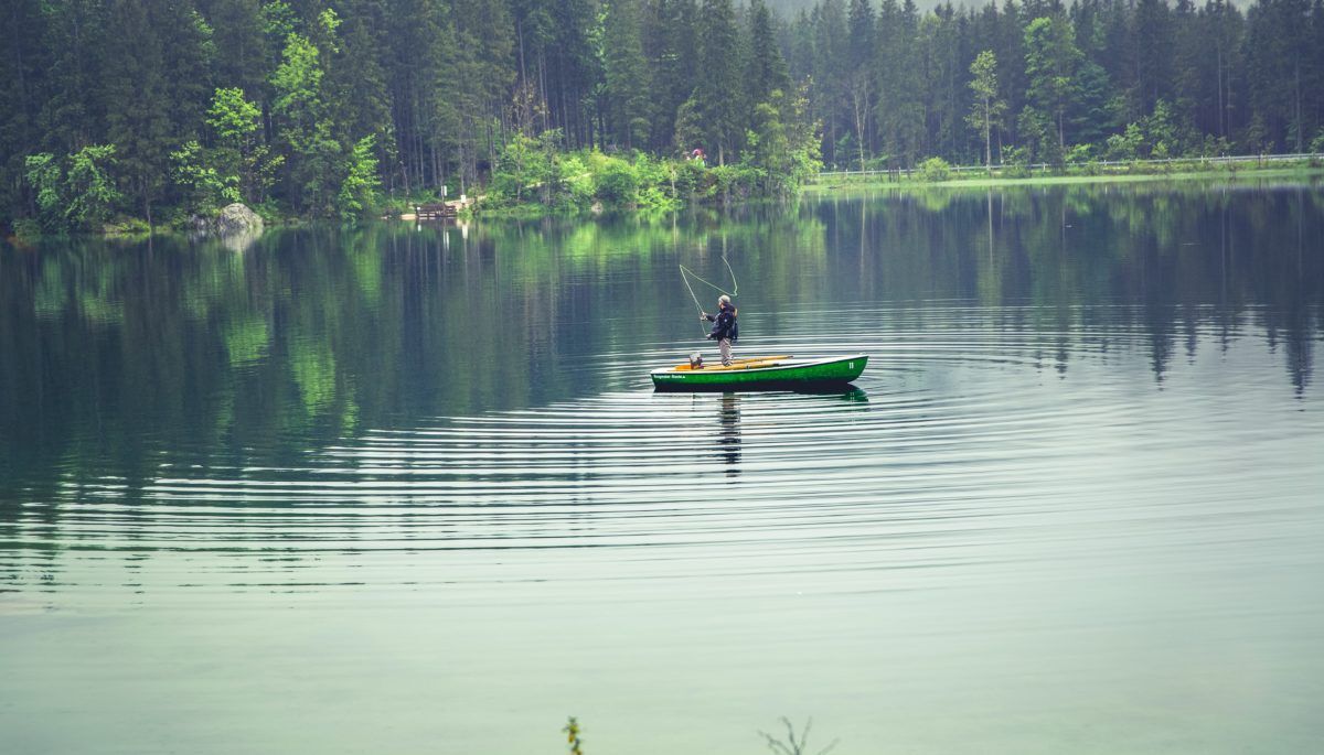 Fisher in boat on lake
