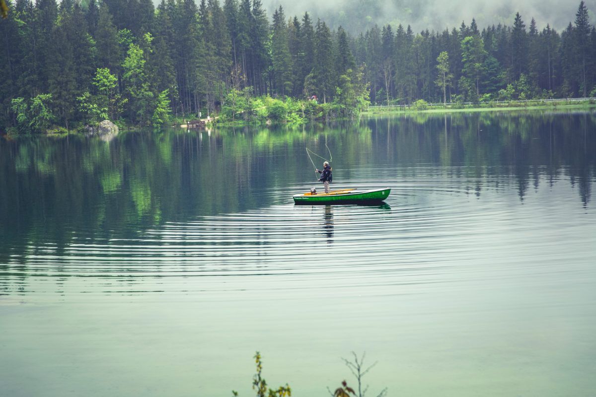 Fisher in boat on lake