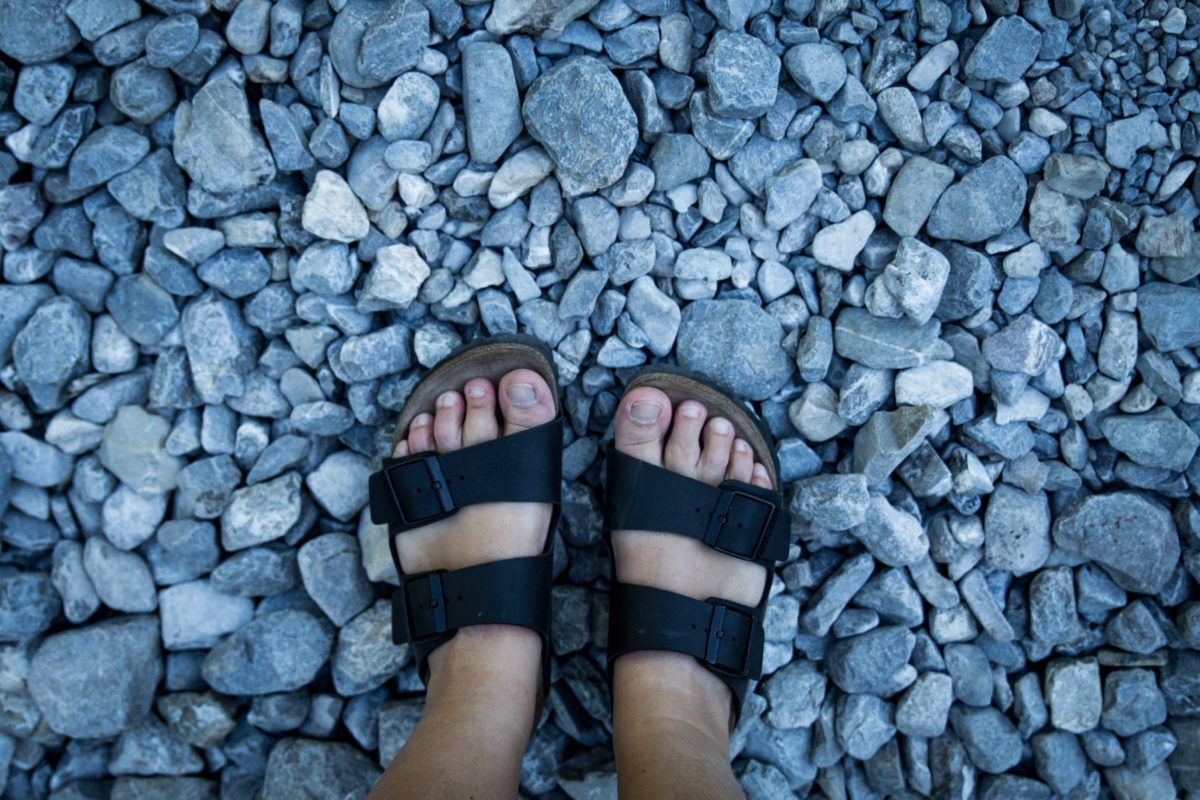 birkenstocks-with-feet-stones-background