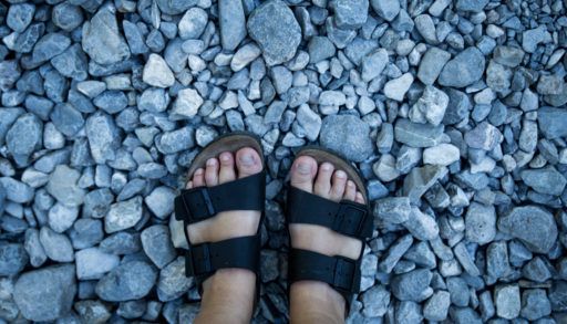 birkenstocks-with-feet-stones-background