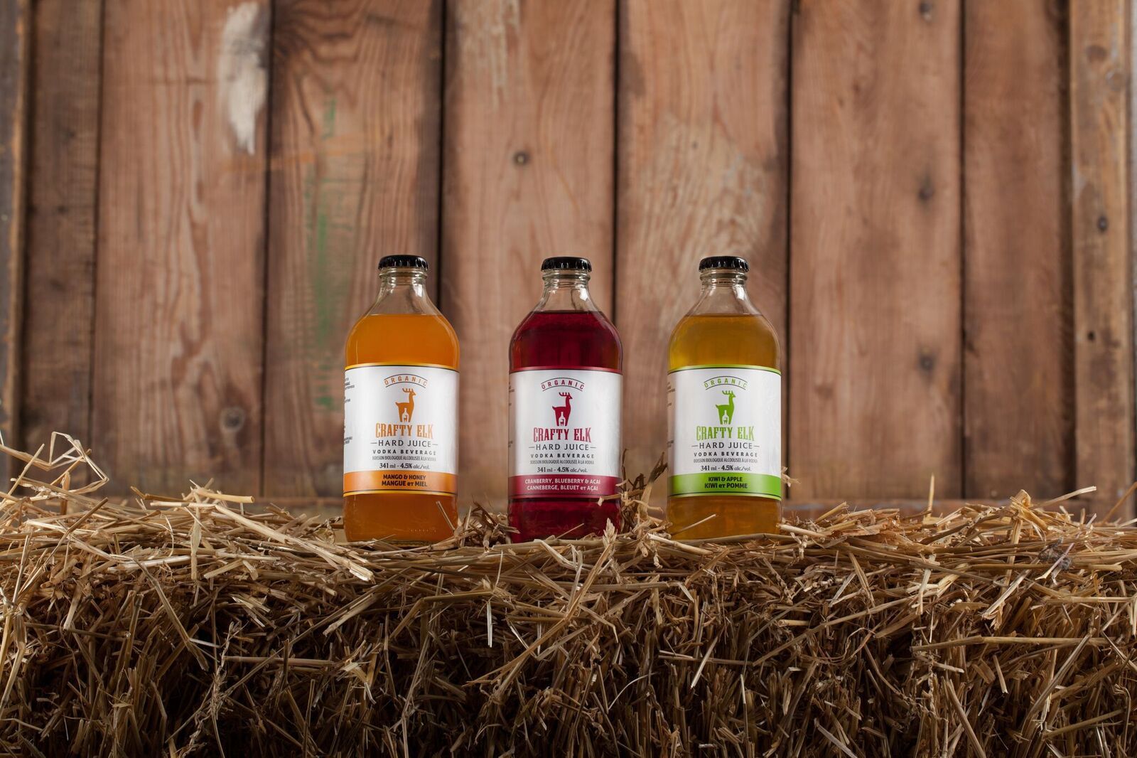 Three bottles sit on a hay bale