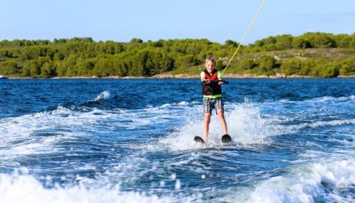 young-boy-waterskiing-on-lake