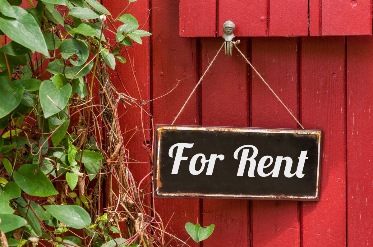 A For Rent sign on a rustic cabin