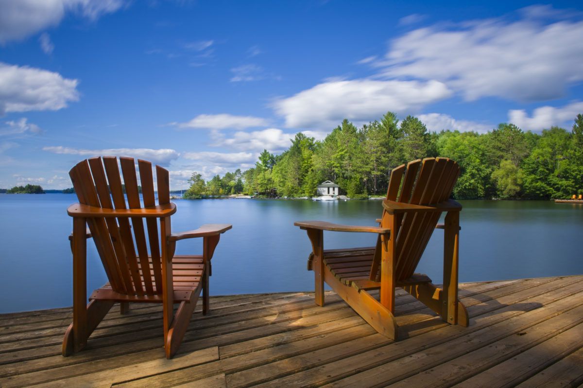Two-Muskoka-chairs-on-a-dock-by-a-lake