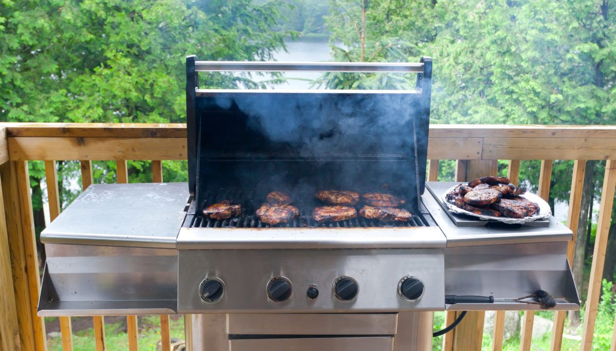 pork-cutlets-on-barbecue-on-deck-overlooking-a-lake
