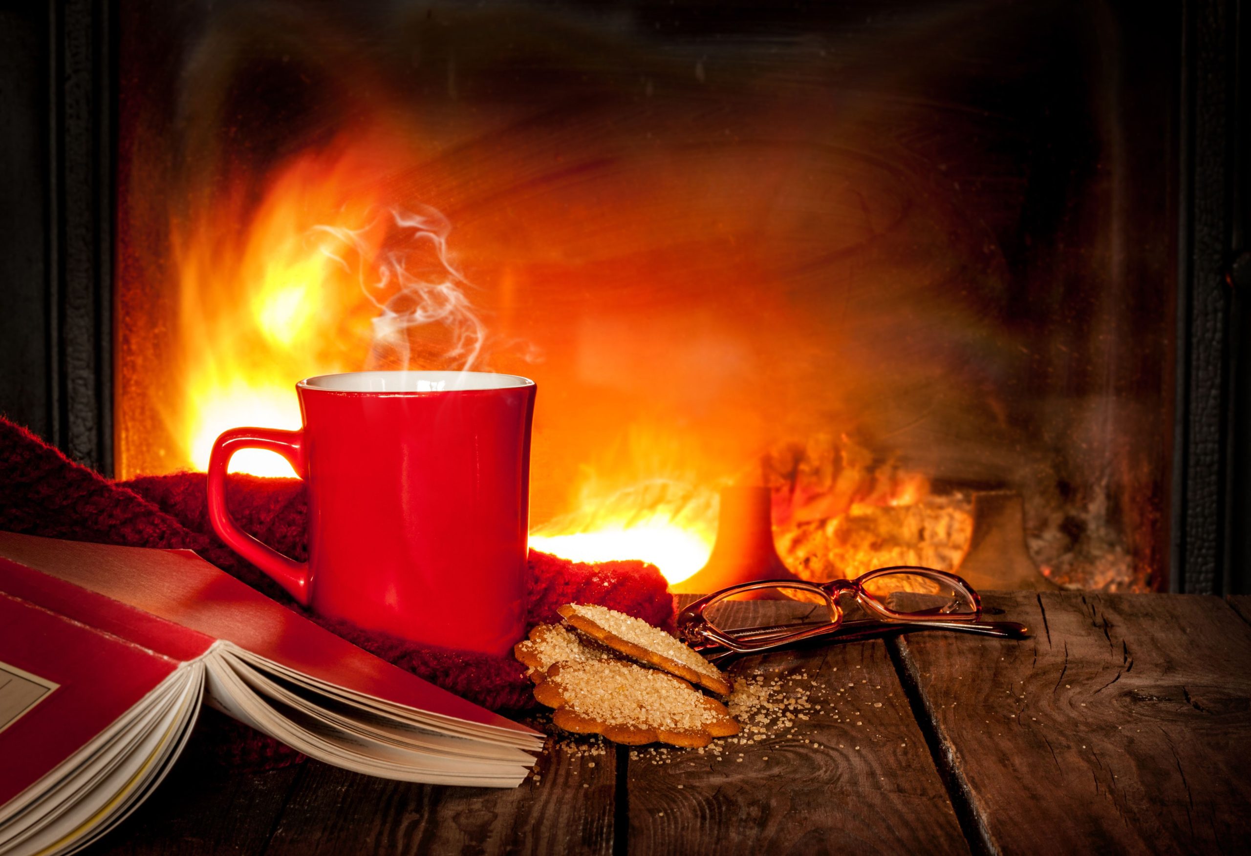 fireplace-with-red-mug-cookies-glasses-and-book-wooden-table