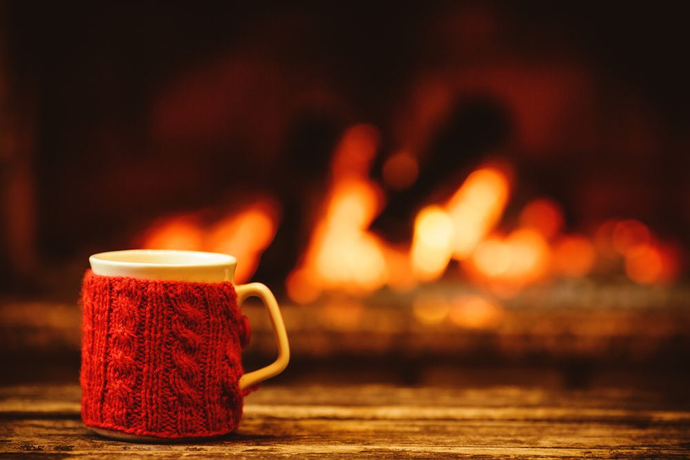 A red mug sitting in front of a fireplace