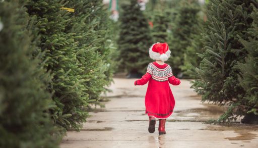 little-girl-running-through-christmas-tree-farm