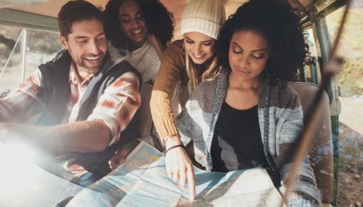 Friends in a car having fun navigating, looking at a map.
