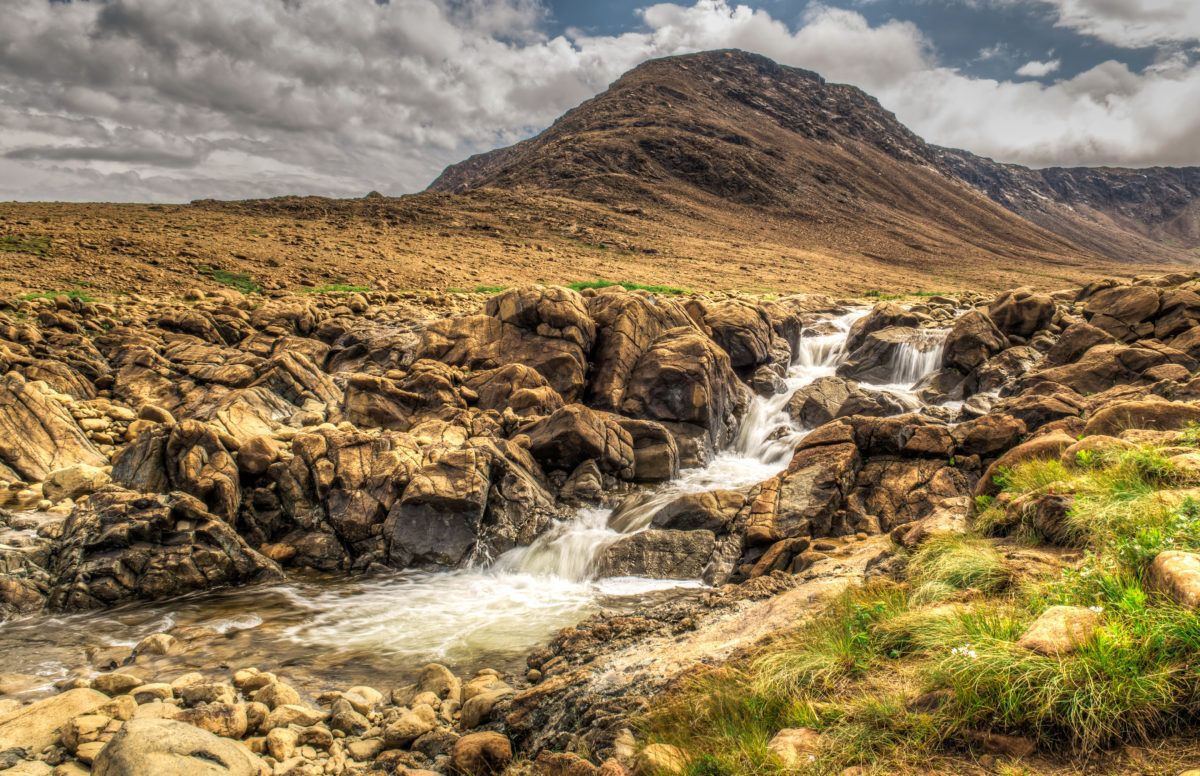 Rocky and grassy Tablelands waterfall in Newfoundland, Canada