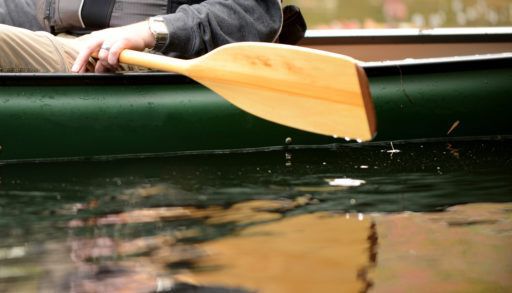 close-up-of-man-with-paddle-on-river-in-canoe