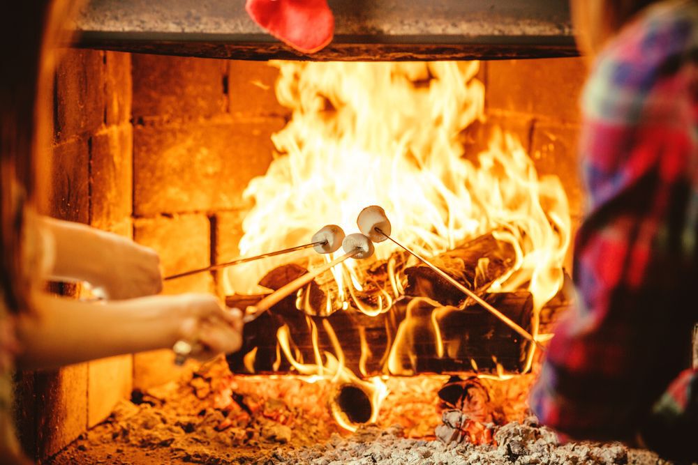 A family roasts marshmallows over a fireplace
