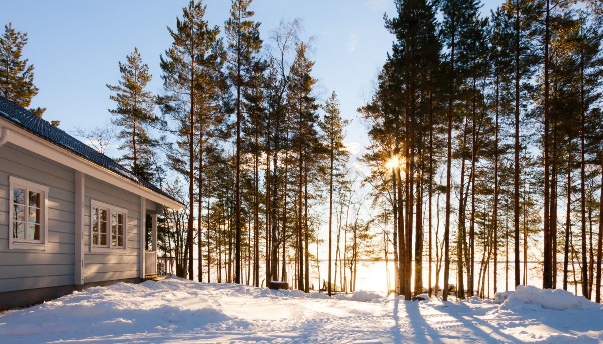 Winter cottage scene with sunshine through the trees