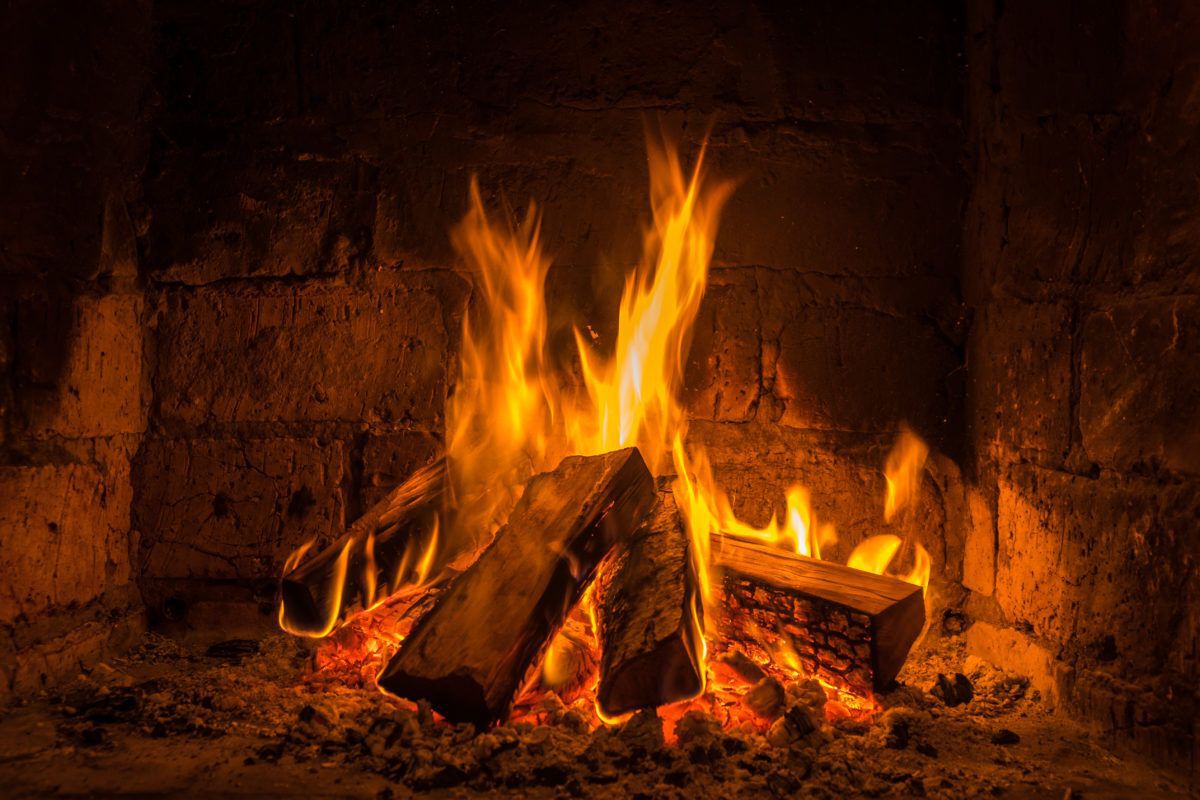 wooden logs burning in a fireplace