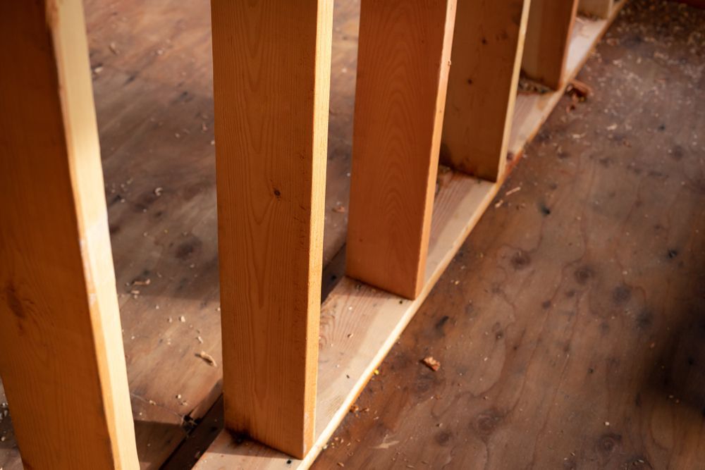 Close up on a row of timber load bearing wall studs, with exposed wood framing, in a home construction background
