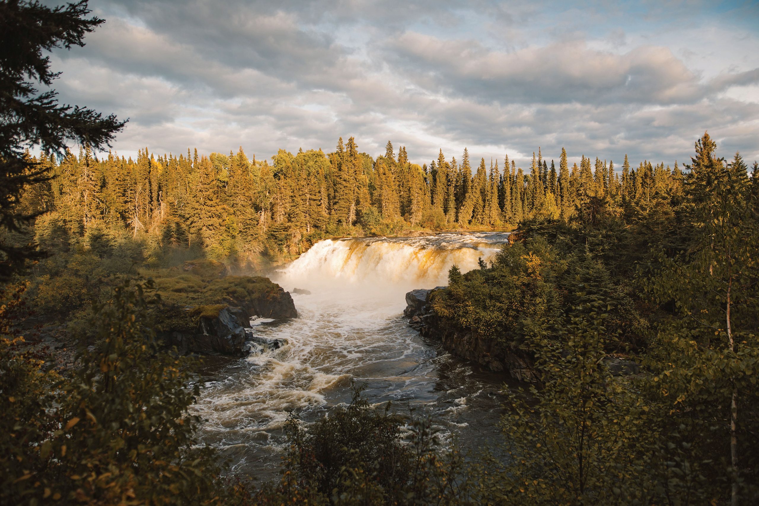 pisew-falls-illuminated-by-the-sun-and-surrounded-by-pines-