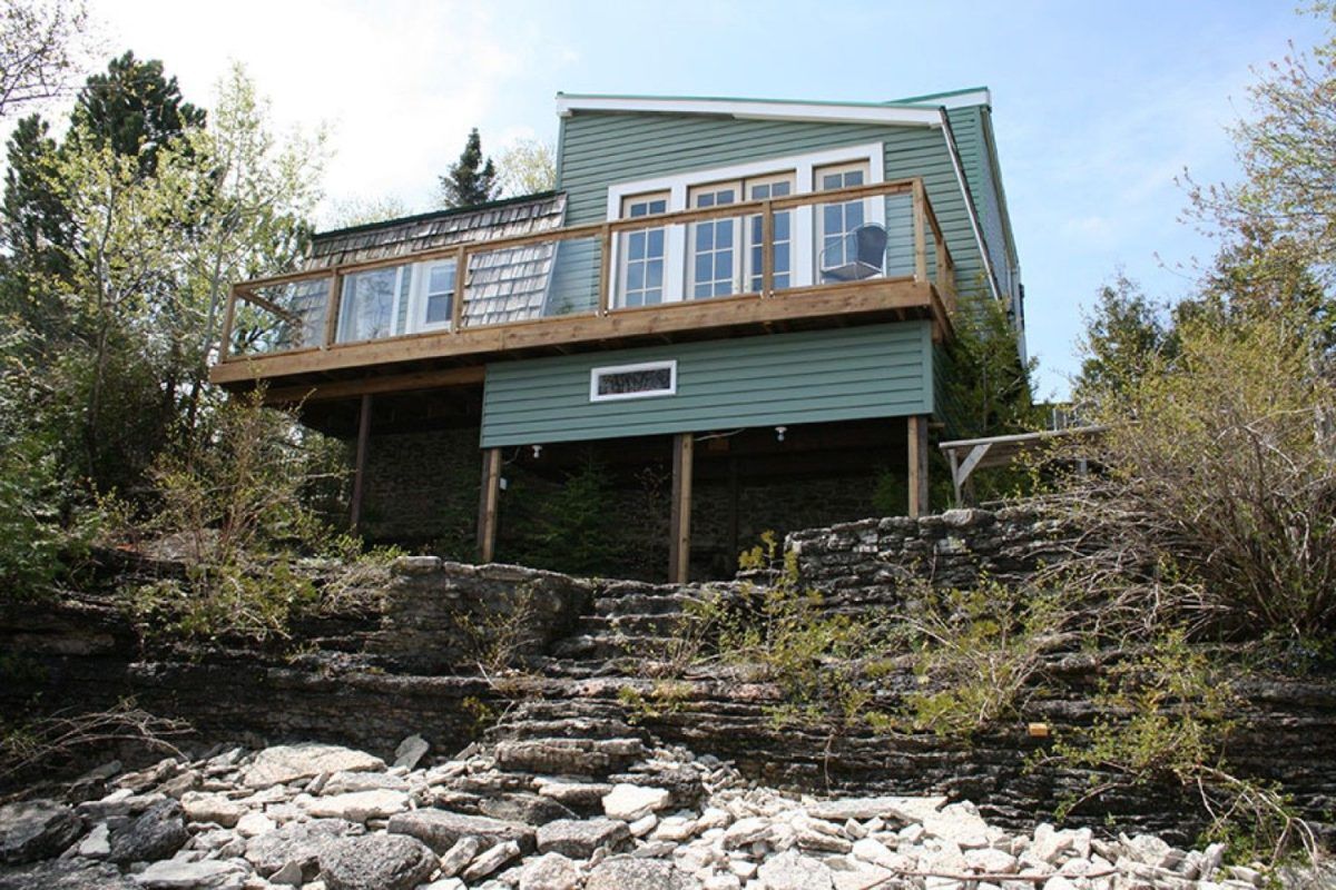 The cottage with steps leading to the water.
