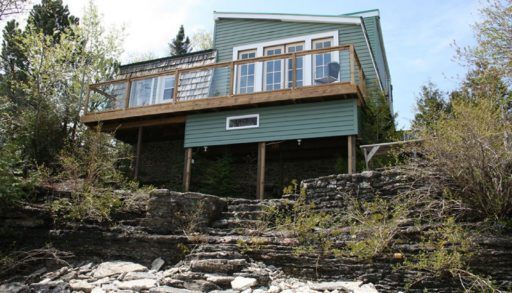 The cottage with steps leading to the water.