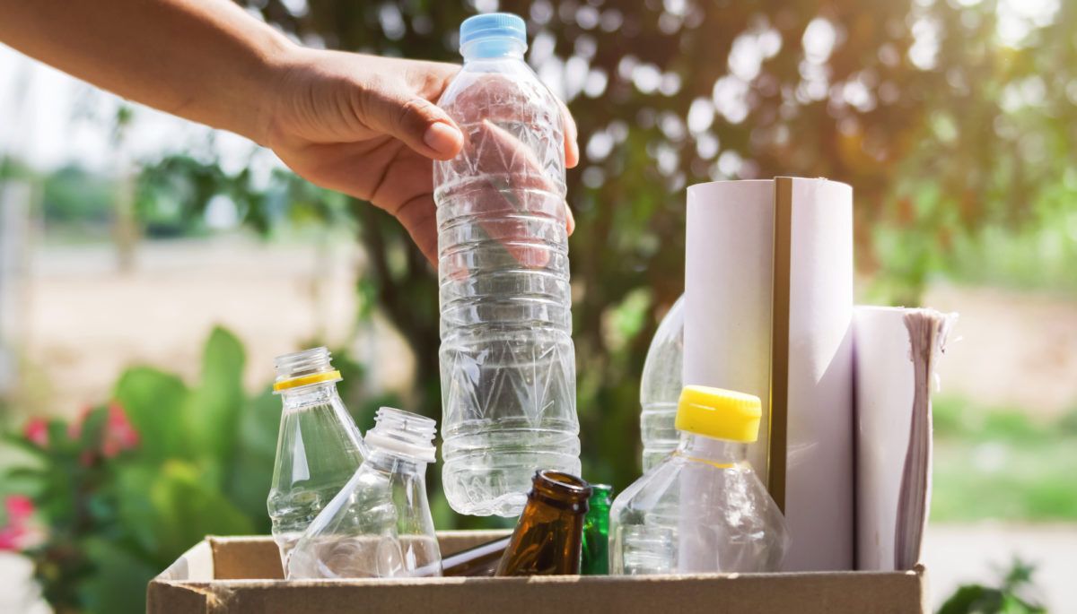 hand putting recycling into cardboard box