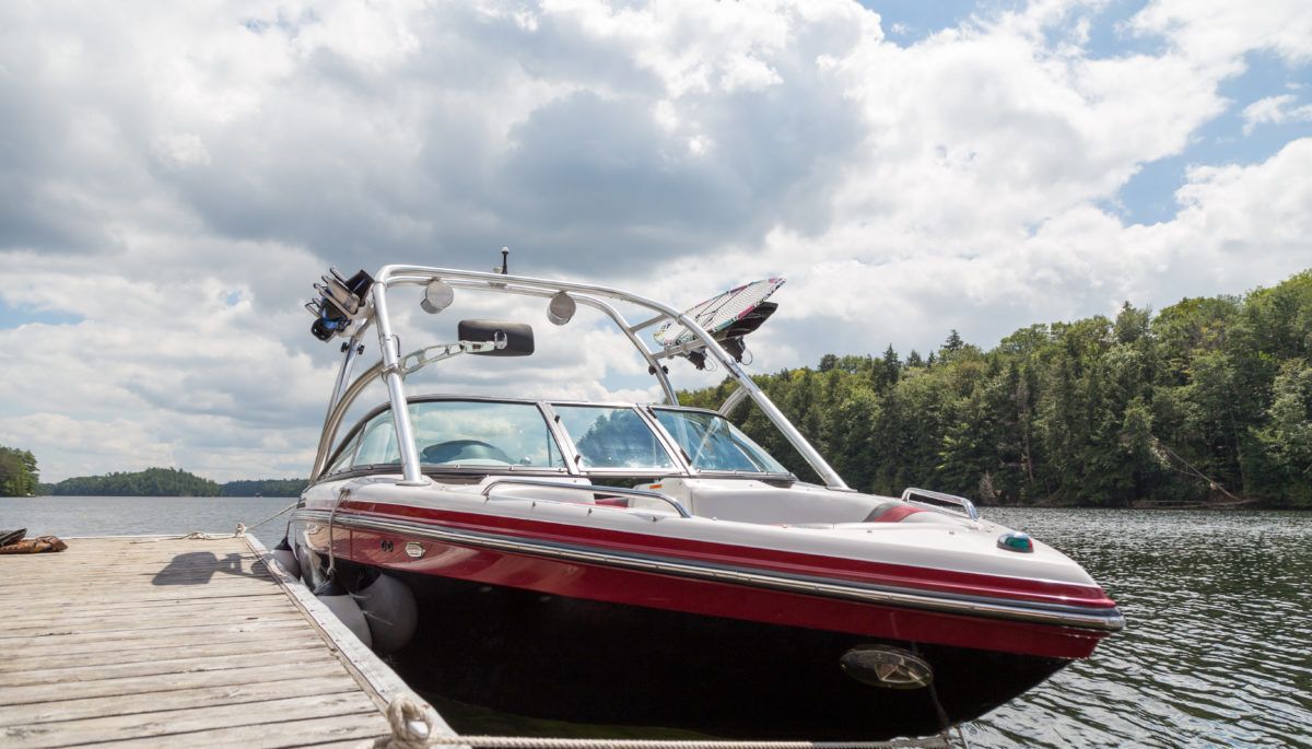 a-wakeboard-boat-at-a-wooden-dock-on-a-sunny-day