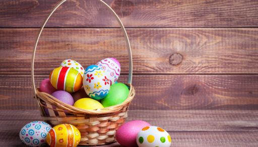 easter-eggs-in-a-basket-wooden-background