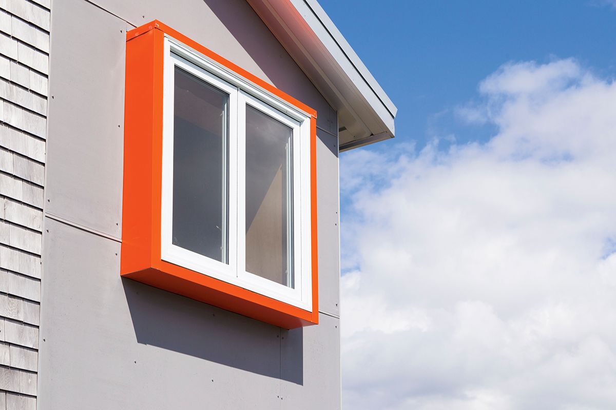 Window with orange trim on grey cottage