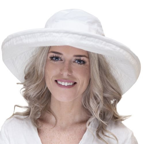 A woman wears a large, white, wide-brimmed hat.