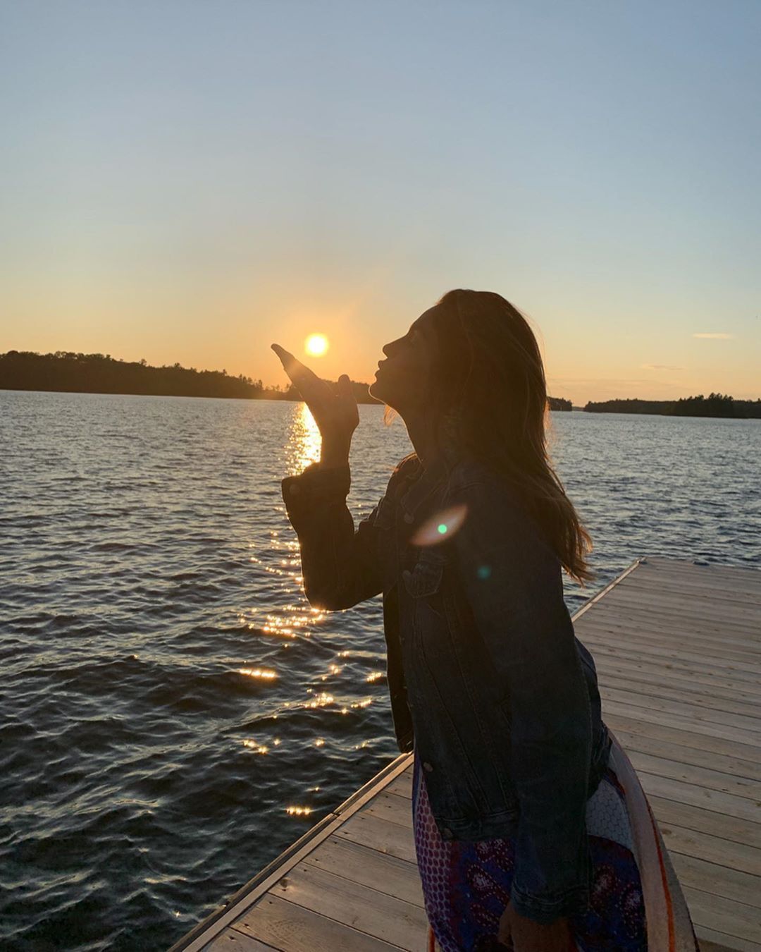 Cindy Crawford on dock with sun setting behind her